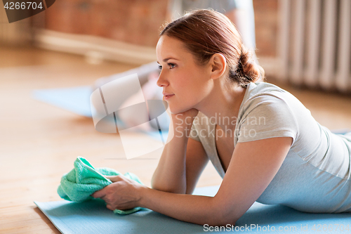 Image of woman resting on yoga mat in gym or studio