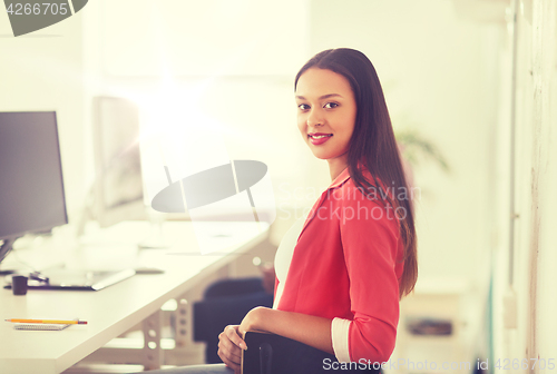 Image of happy african woman with computer at office