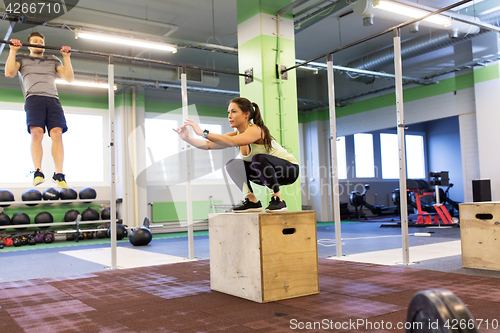 Image of woman and man exercising in gym