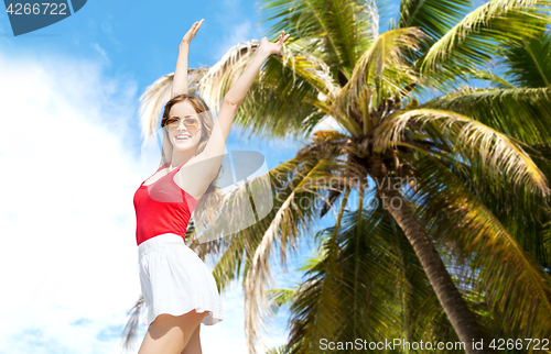 Image of happy young woman in sunglasses on summer beach