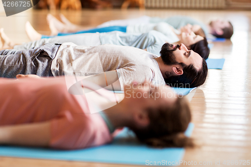 Image of group of people making yoga exercises at studio