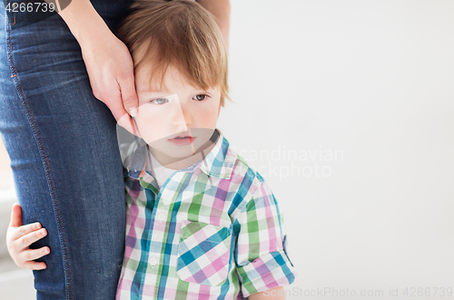 Image of sad little boy holding to mother