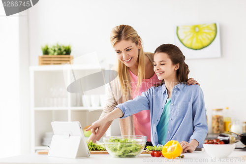 Image of family cooking dinner using tablet pc at kitchen