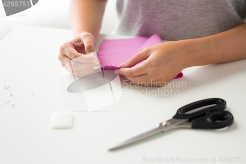 Image of woman with needle stitching fabric pieces