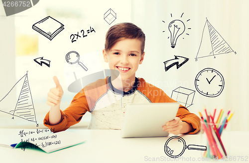 Image of happy boy with tablet pc showing thumbs up at home