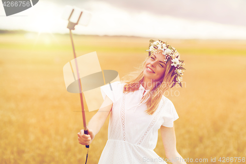 Image of happy young woman taking selfie by smartphone