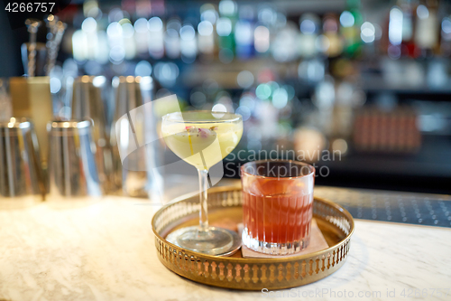 Image of tray with glasses of cocktails at bar