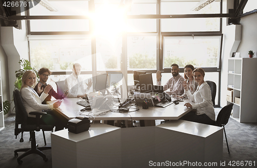 Image of business team waving hands at office