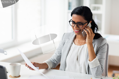 Image of businesswoman calling on smartphone at office