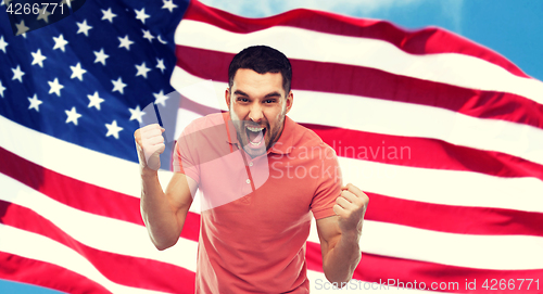 Image of angry man showing fists over american flag