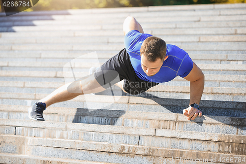 Image of Fit man doing exercises outdoors at park