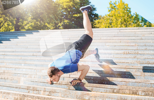 Image of Fit man doing exercises outdoors at park