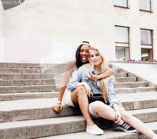 Image of Two teenage girls infront of university building smiling, having fun traveling europe, lifestyle people concept 