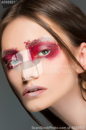 Image of Beautiful woman face portrait close up with red make up