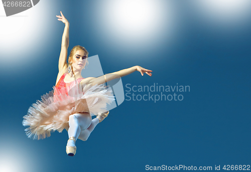 Image of Beautiful female ballet dancer on a grey background. Ballerina is wearing pink tutu and pointe shoes.