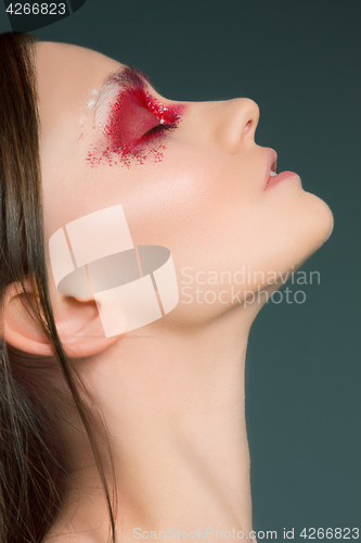 Image of Beautiful woman face portrait close up with red make up