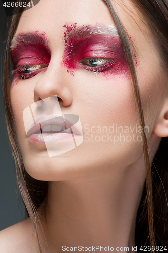 Image of Beautiful woman face portrait close up with red make up