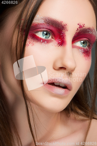 Image of Beautiful woman face portrait close up with red make up