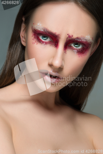 Image of Beautiful woman face portrait close up with red make up