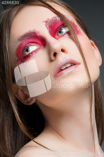Image of Beautiful woman face portrait close up with red make up