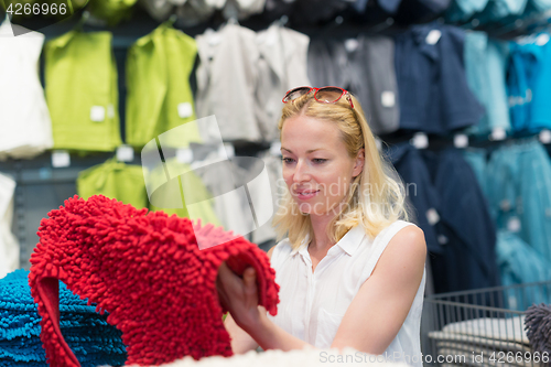 Image of Woman choosing the right item for her apartment in a modern home furnishings store.