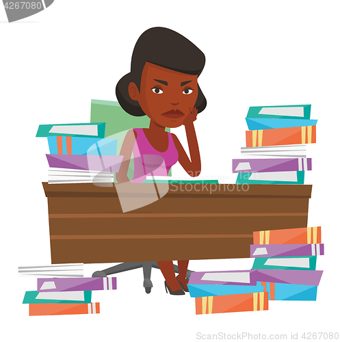 Image of Student sitting at the table with piles of books.