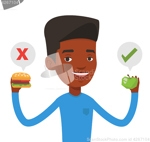 Image of Man choosing between hamburger and cupcake.