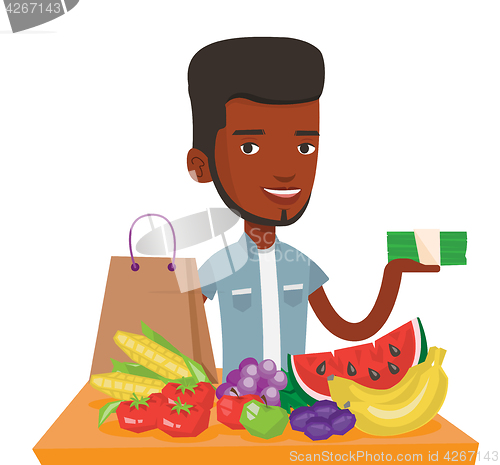 Image of Young man standing at the table with shopping bag