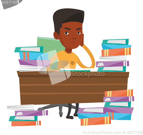 Image of Student sitting at the table with piles of books.