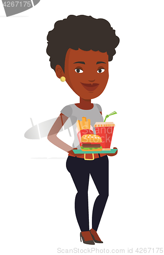 Image of Woman holding tray full of fast food.