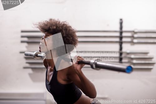 Image of black woman lifting empty bar