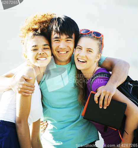 Image of cute group of teenages at the building of university with books huggings