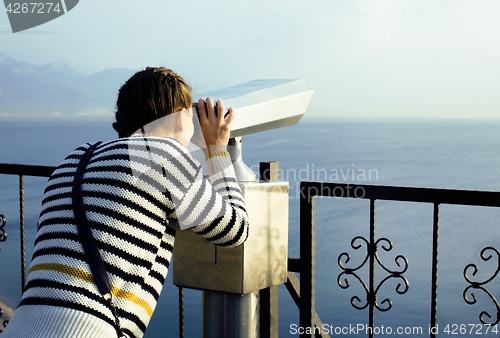 Image of young woman looking through telescope at sea viewpoint in Ataturk park