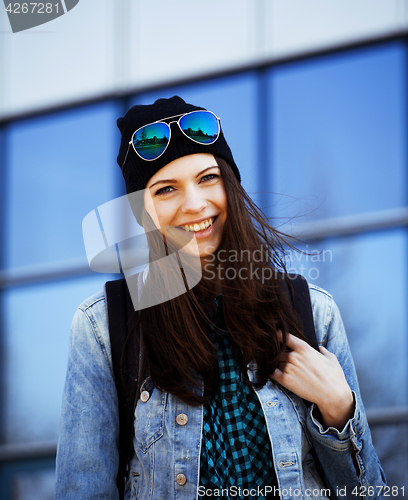 Image of cute brunette teenage girl in hat, student outside