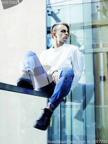 Image of young modern hipster guy at new building university blond fashio