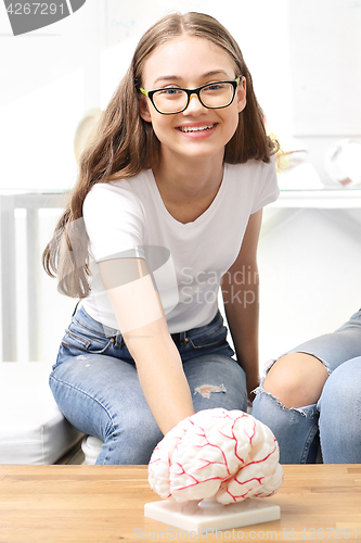 Image of Schoolgirl watching model of the human brain.