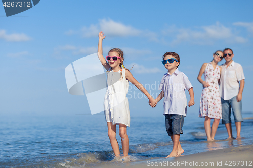 Image of Happy family walking on the beach at the day time.