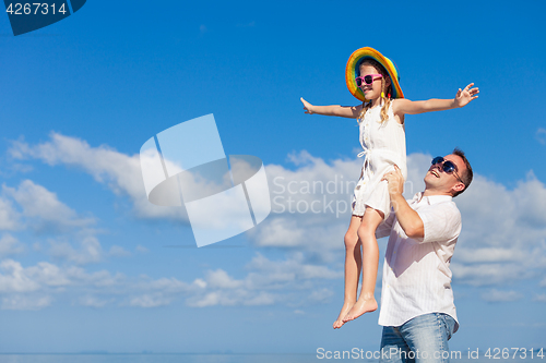 Image of Father and daughter playing on the beach at the day time.