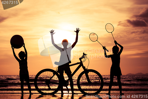 Image of Happy children playing on the beach at the sunset time.