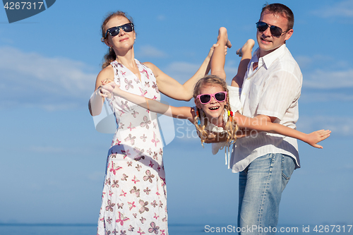 Image of Happy family walking on the beach at the day time.