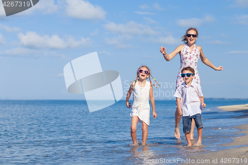 Image of Mother and children playing on the beach at the day time.