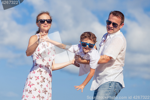 Image of Happy family walking on the beach at the day time.