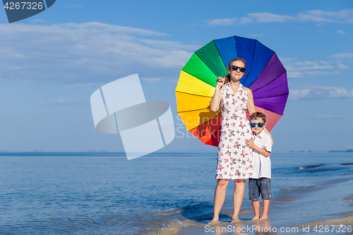 Image of Mother and son playing on the beach at the day time.