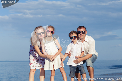 Image of Happy family walking on the beach at the day time.