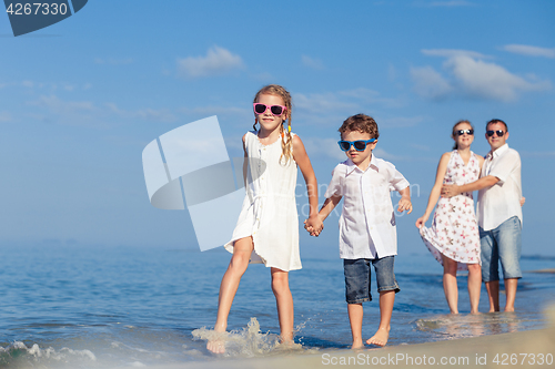 Image of Happy family walking on the beach at the day time.