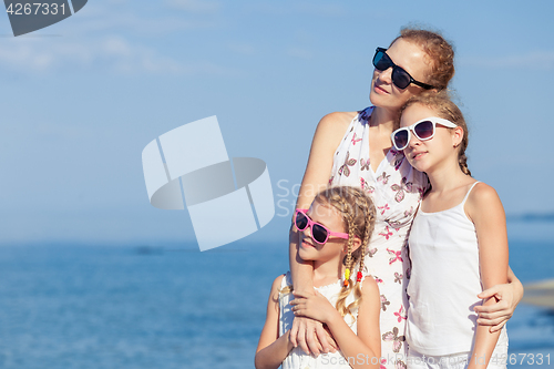 Image of Mother and children playing on the beach at the day time.