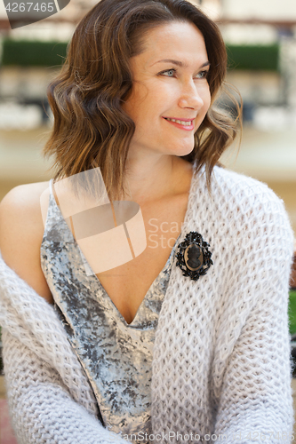 Image of smiling beautiful woman with a black cameo brooch