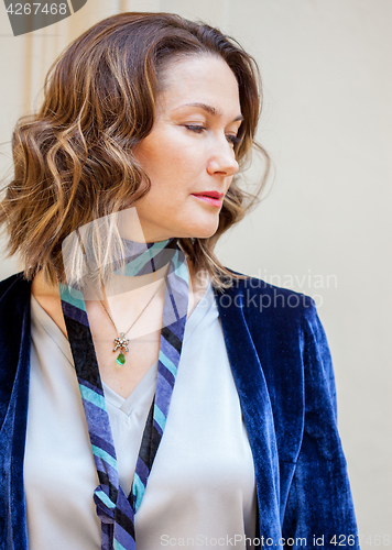 Image of woman in a purple jacket with a pendant around her neck