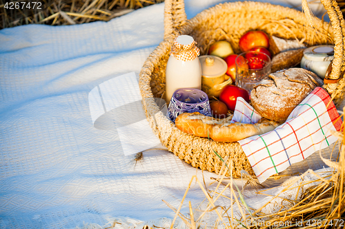 Image of Bread, milk and apples in a basket.