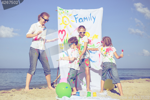 Image of Mother and children playing on the beach at the day time.